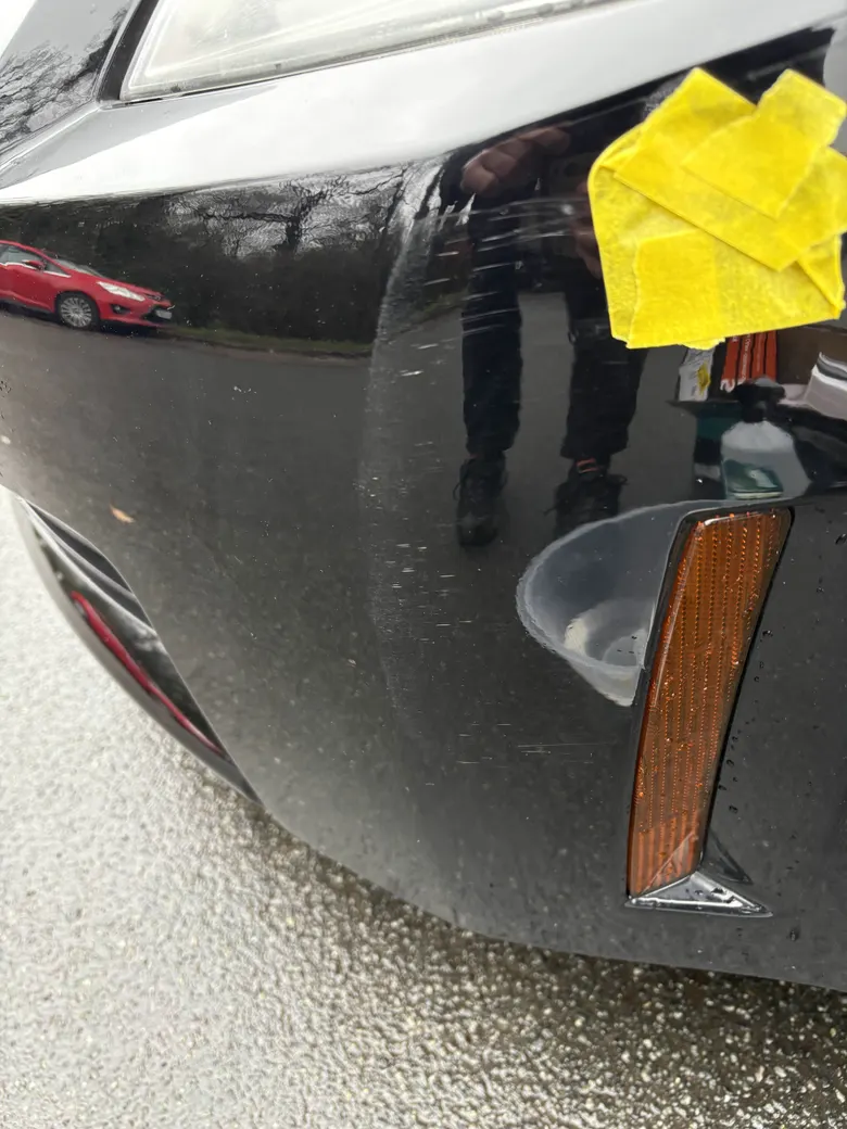 Before: a black front bumper beside an orange side marker, swirls and scratches visible under a taped 50/50 test line